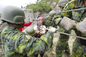 13日，臺灣高雄縣六龜鄉(xiāng)新開村有20多戶遭泥石流淹沒。圖為軍人正陸續(xù)將生還者救出。