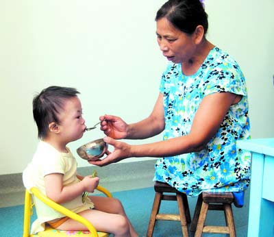 許月華在給孩子喂飯。劉炬 攝