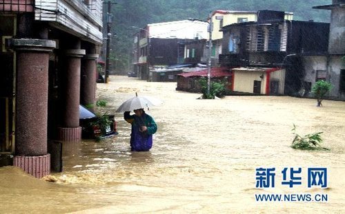 10月21日，臺(tái)灣宜蘭縣蘇澳地區(qū)居民在洪水中艱難出行。新華社發(fā) 