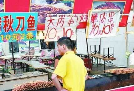 被查后，美食街上的'羊肉串'的'羊'字被涂抹了。