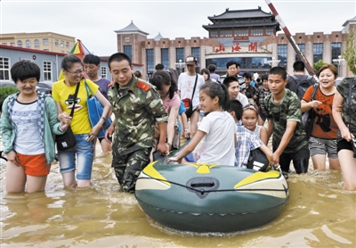 昨日，消防戰(zhàn)士在秦皇島市山海關(guān)火車站涉水運(yùn)送旅客。當(dāng)日，受持續(xù)強(qiáng)降雨影響，河北省秦皇島市海港區(qū)、山海關(guān)區(qū)等地出現(xiàn)內(nèi)澇，部分列車停運(yùn)。 新華社發(fā)