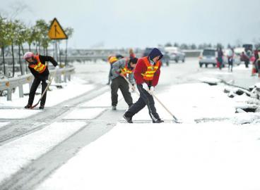 工作人員清理高速路上的積雪。 張磊攝